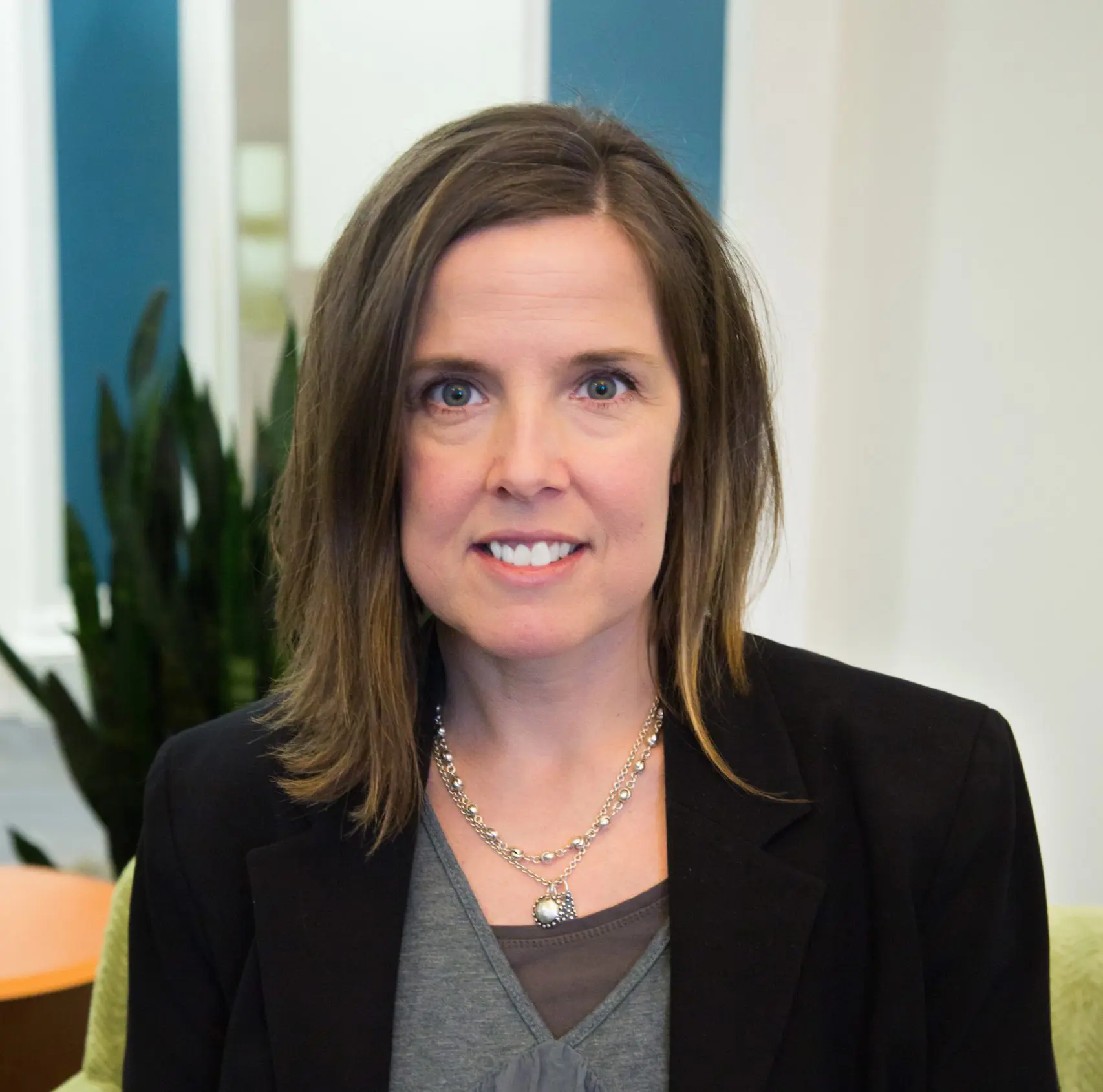 Liz Donovan sits in a lime green chair for a picture