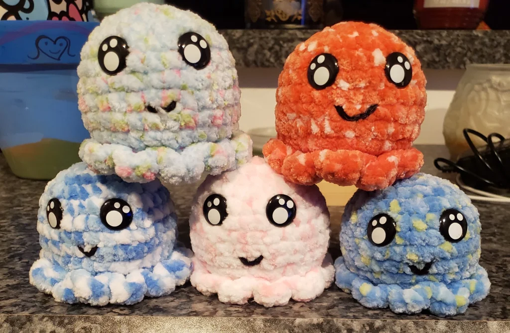 5 crocheted octopi sit on a counter one on top of the other