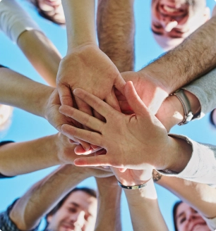 a view from below of teammates touching hands in a show of solidarity
